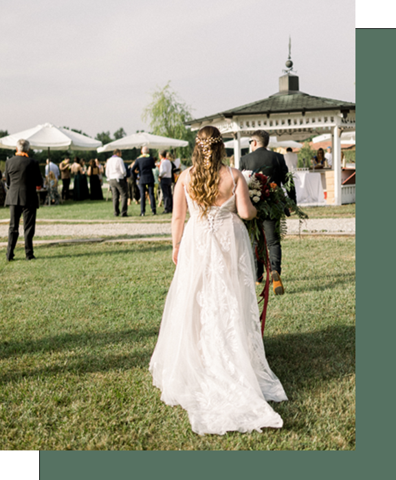 Due sposi nel giorno del loro matrimonio country chic al podere di binse camminano nel prato